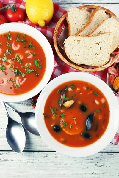 Tasty soups with  sea food in bowls on wooden background — Stock Photo, Image