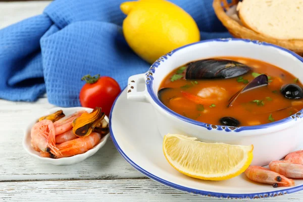 美味汤配虾、 贻贝、 番茄和黑橄榄木背景上碗里 — 图库照片