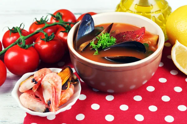 Sopa sabrosa con gambas, mejillones, tomates y aceitunas negras en un bol sobre fondo de madera — Foto de Stock