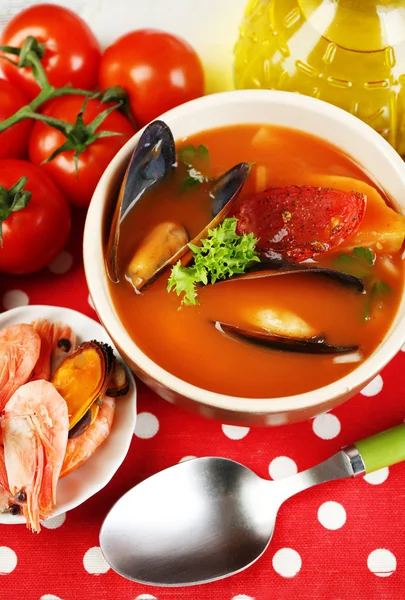 Tasty soup with shrimps, mussels, tomatoes and black olives in bowl on wooden background — Stock Photo, Image