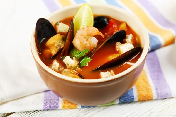 Sopa saborosa com camarões, mexilhões, tomates e azeitonas pretas em tigela sobre fundo de madeira — Fotografia de Stock