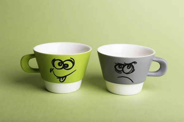 Emotional cups on green background — Stock Photo, Image