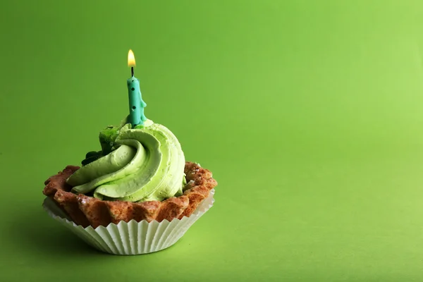 Cake van de kindverjaardag cup met kaars op groene achtergrond — Stockfoto