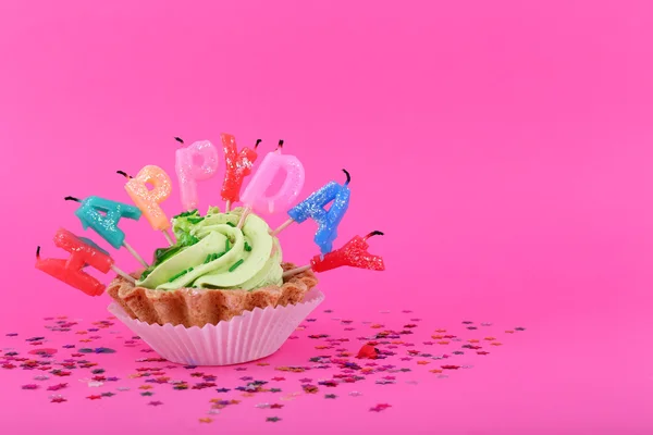 Kake med bursdagslys på rosa bakgrunn – stockfoto