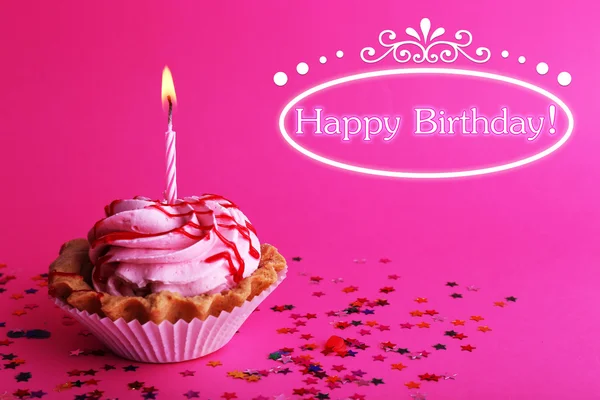 Urodziny ciasto z świeca i kolorowe gwiazdki na różowym tle — Zdjęcie stockowe