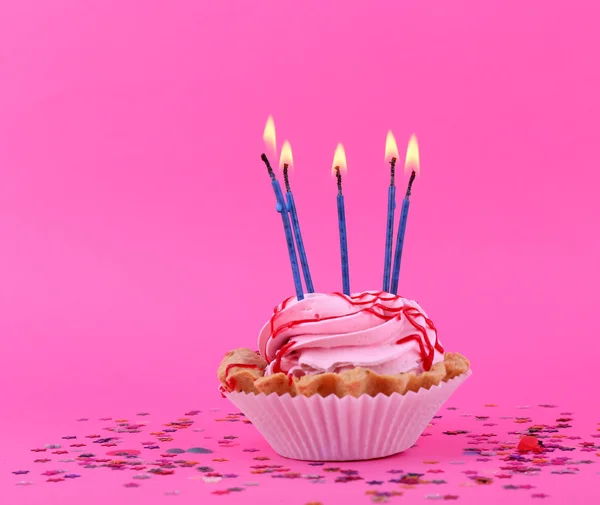 Bolo de aniversário com velas e estrelas coloridas no fundo rosa — Fotografia de Stock