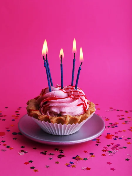 Cake van de kindverjaardag cup met kaarsen en kleurrijke sterren op roze achtergrond — Stockfoto