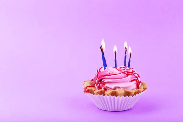 Bolo com velas de aniversário no fundo roxo — Fotografia de Stock