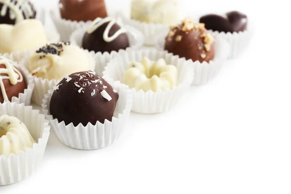 Deliciosos caramelos de chocolate sobre fondo blanco —  Fotos de Stock