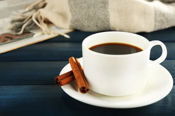 Taza de café con periódico, cuadros y canela sobre fondo de madera de color — Foto de Stock