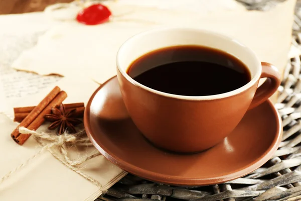 Taza de café con sobres sobre soporte de mimbre sobre fondo de mesa de madera —  Fotos de Stock