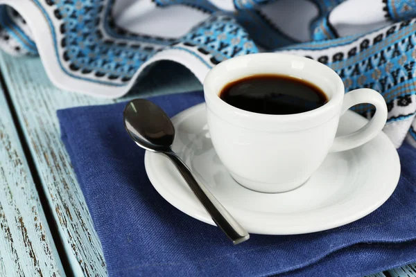 Xícara de café em guardanapo azul com colher e toalha de mesa sobre fundo de madeira cor — Fotografia de Stock