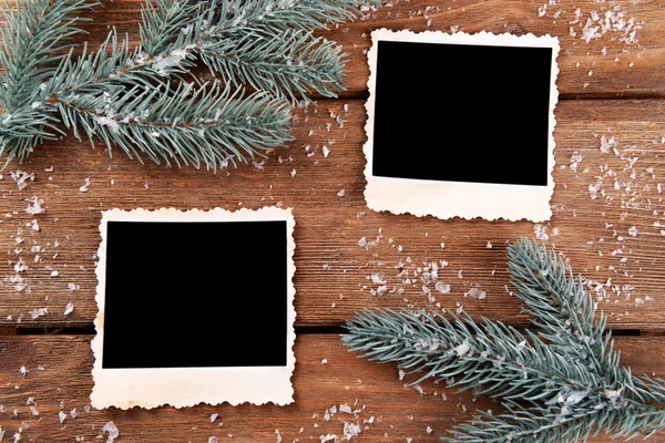 Lege fotokaders en Spar boom met sneeuwvlokken op houten tafel achtergrond — Stockfoto