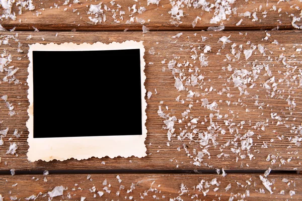 Cadre photo vierge et flocons de neige sur fond de table en bois — Photo