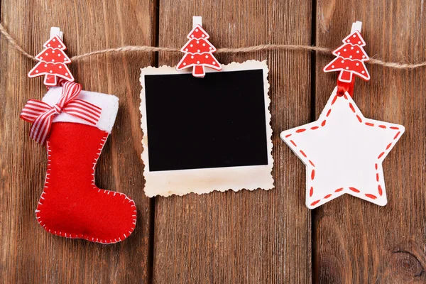 Moldura de foto em branco e decoração de Natal na corda, no fundo de madeira — Fotografia de Stock