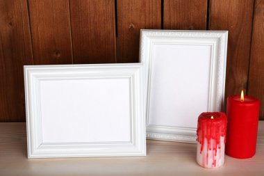 Mumlar ve ahşap yüzey ve ahşap duvar zemin üzerine kitaplar ile fotoğraf çerçeveleri