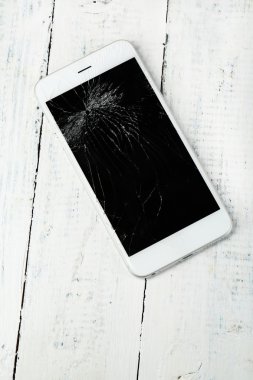 Ahşap arka plan üzerinde kırık iphone