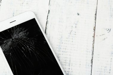 Ahşap arka plan üzerinde kırık iphone