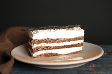 Leziz tiramisu pasta plaka, siyah arka plan üzerine ahşap masa üzerinde