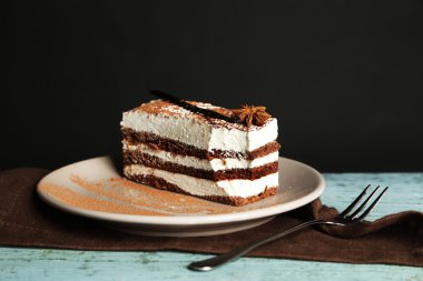 Leziz tiramisu pasta plaka, siyah arka plan üzerine ahşap masa üzerinde