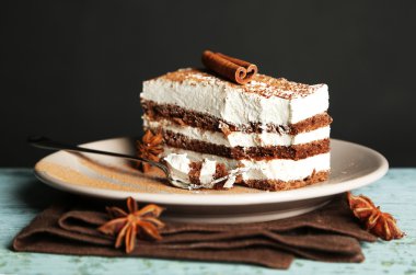 Leziz tiramisu pasta plaka, siyah arka plan üzerine ahşap masa üzerinde