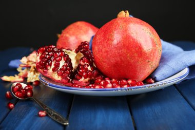 Koyu arka plan üzerinde ahşap masa üzerinde sulu olgun nar