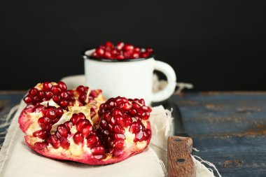 Koyu arka plan üzerinde ahşap masa üzerinde sulu olgun nar