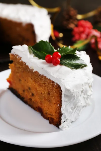 Fatia de bolo coberto de creme com decoração de Natal em fundo de mesa de madeira — Fotografia de Stock