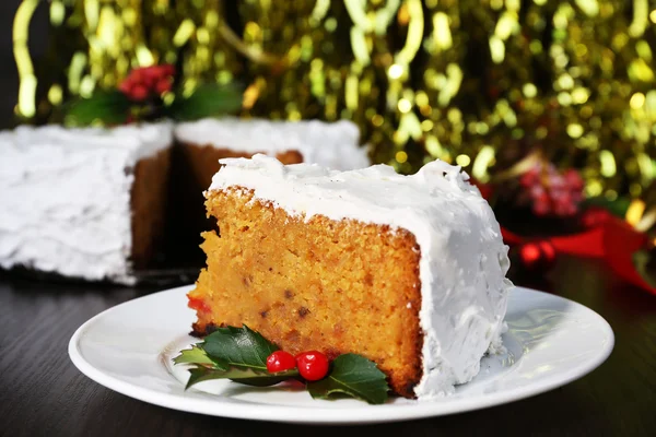 Fetta di torta crema coperta con decorazione natalizia su tavolo di legno e sfondo luminoso — Foto Stock