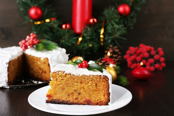 Rebanada de crema cubierta de pastel con decoración de Navidad sobre fondo de mesa de madera —  Fotos de Stock