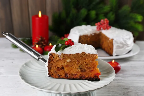 切片蛋糕覆盖奶油圣诞装饰在桌子上，对木墙背景 — 图库照片