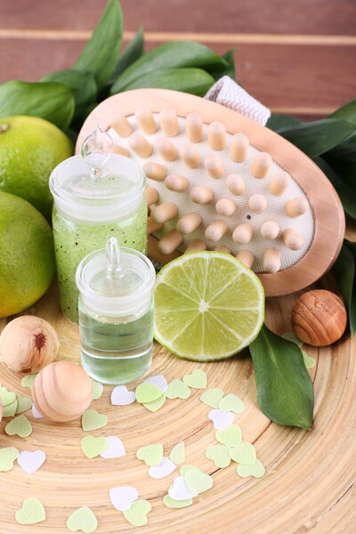 Spa composition with lime on wooden plate and wooden table background