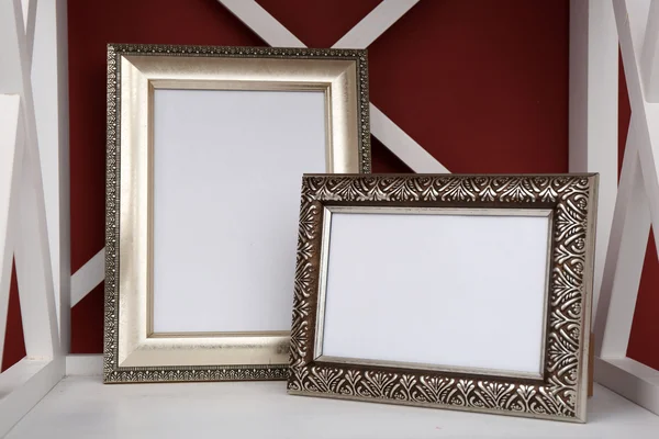 Twee foto frames op de plank, op een muur achtergrond kleur — Stockfoto