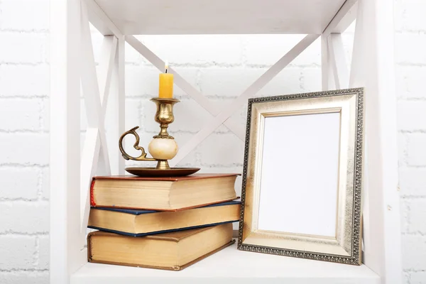 Photo frame with candlestick and books — Stock Photo, Image