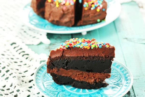 Gâteau au chocolat avec poudre sucrée colorée sur la table close-up — Photo