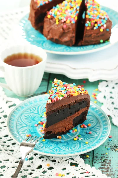 Gâteau au chocolat avec poudre sucrée colorée sur la table close-up — Photo