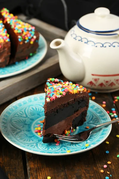 Pastel de chocolate con colorido polvo dulce en primer plano de la mesa — Foto de Stock