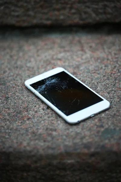 Зламаний телефон на асфальті — стокове фото