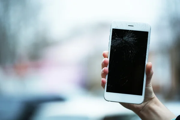 Broken iPhone on hand outdoors — Stock Photo, Image