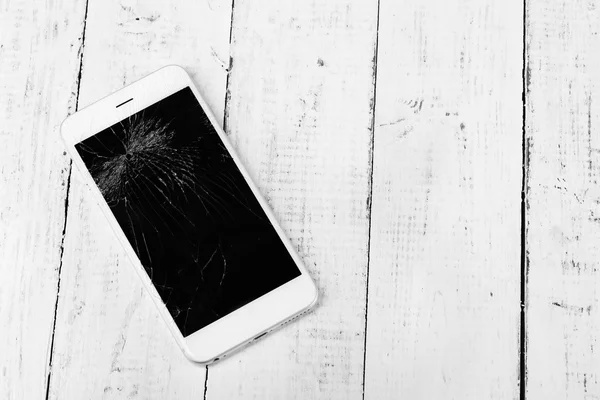 Broken iphone na dřevěné pozadí — Stock fotografie