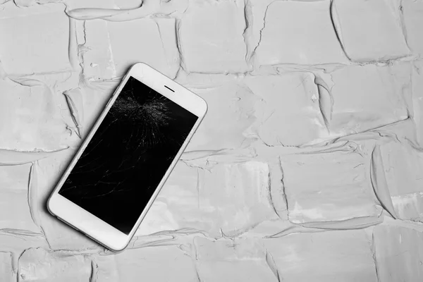 Сломанный iPhone на кирпичном фоне — стоковое фото