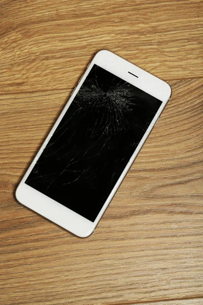 Broken iPhone on wooden background — Stock Photo, Image