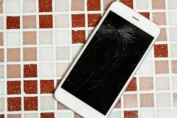 Broken iPhone on mosaic tile background — Stock Photo, Image