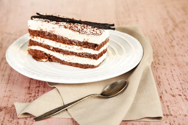 Lekkere tiramisu taart op plaat, op houten tafel — Stockfoto