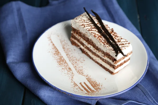 Sabroso pastel de tiramisú en plato, sobre mesa de madera —  Fotos de Stock