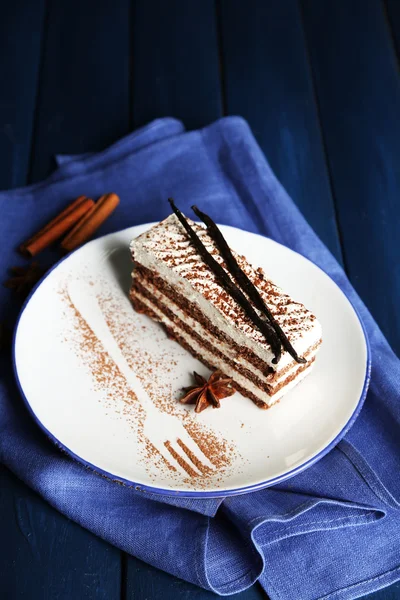 Sabroso pastel de tiramisú en plato, sobre mesa de madera —  Fotos de Stock