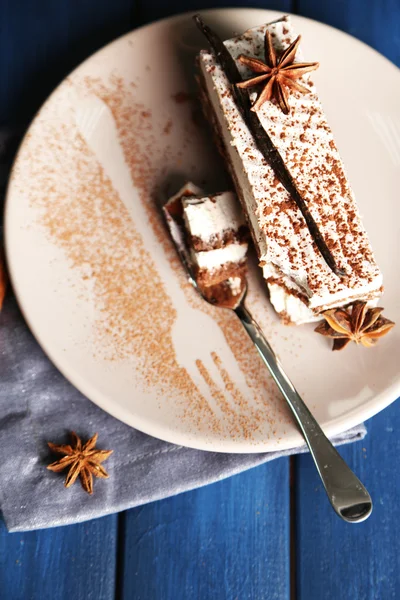 Tasty tiramisu cake on plate, on wooden table — Stock Photo, Image