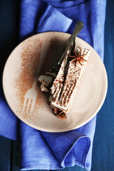 Tasty tiramisu cake on plate, on wooden table — Stock Photo, Image