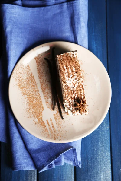 Gustosa torta tiramisù su piatto, su tavolo di legno — Foto Stock