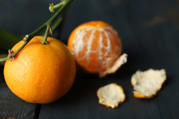 Tangerinas maduras suculentas com folhas na mesa de madeira — Fotografia de Stock